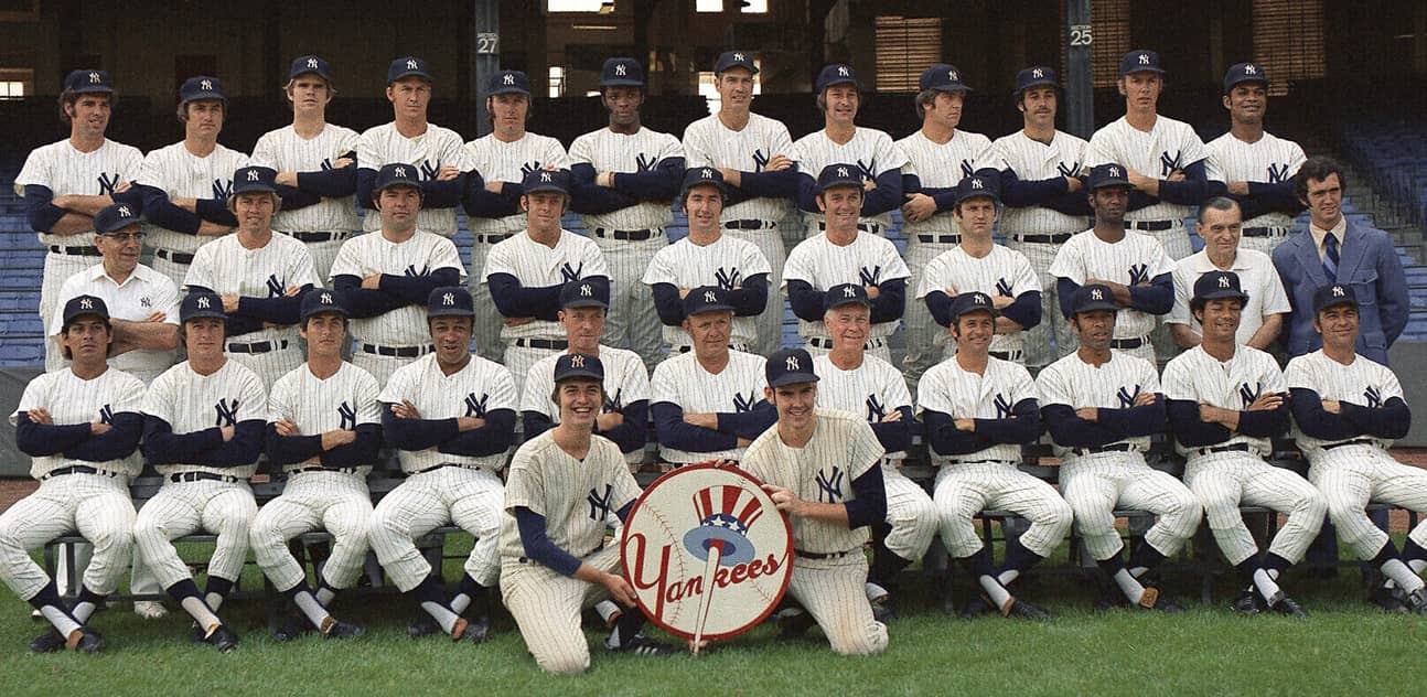 The New York Yankees pose for a group portrait in 1972. From left to right, front row: Celerino Sanchez, Bobby Murcer, Fred Beene, Elston Howard, Jim Hegan, Ralph Houk, Jim Turner, Dick Howser, Horace Clarke, Roy White, Johnny Callison. Second row: Joe Soares, Hal Lanier, Ron Swoboda, Ron Blomberg, Rob Gardner, Bernie Allen, Thurman Munson, Jerry Kenney, Pete Sheehy, Rob Franklin. Third row: Mike Kekich, Fritz Peterson, Steve Kline, Mel Stottlemyre, Sparky Lyle, Charlie Spikes, Lindy McDaniel, Ron Klimkowski, John Ellis, Wade Blasingame, Gene Michael, Felipe Alou. Seated on ground: batboys Kevin Melchior and Gerry Murphy.