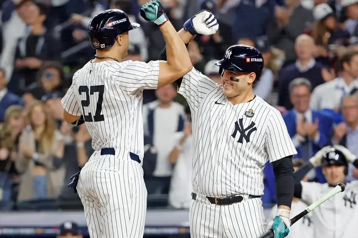 Giancarlo Stanton is greeted by Anthony Rizzo after he scores on his solo home run during the third inning of Game 5 of the World Series against the Dodgers.