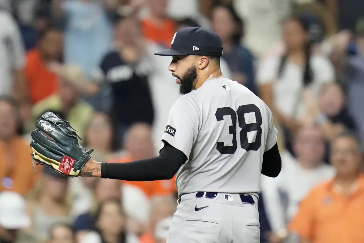 New York Yankees relief pitcher Devin Williams (38) exchanges words with home plate umpire Brian Walsh as he walked back to the dugout after giving up a run walking Houston Astros’ Taylor Trammell with the bases loaded during the eighth inning of a baseball game Wednesday, Sept. 3, 2025, in Houston.