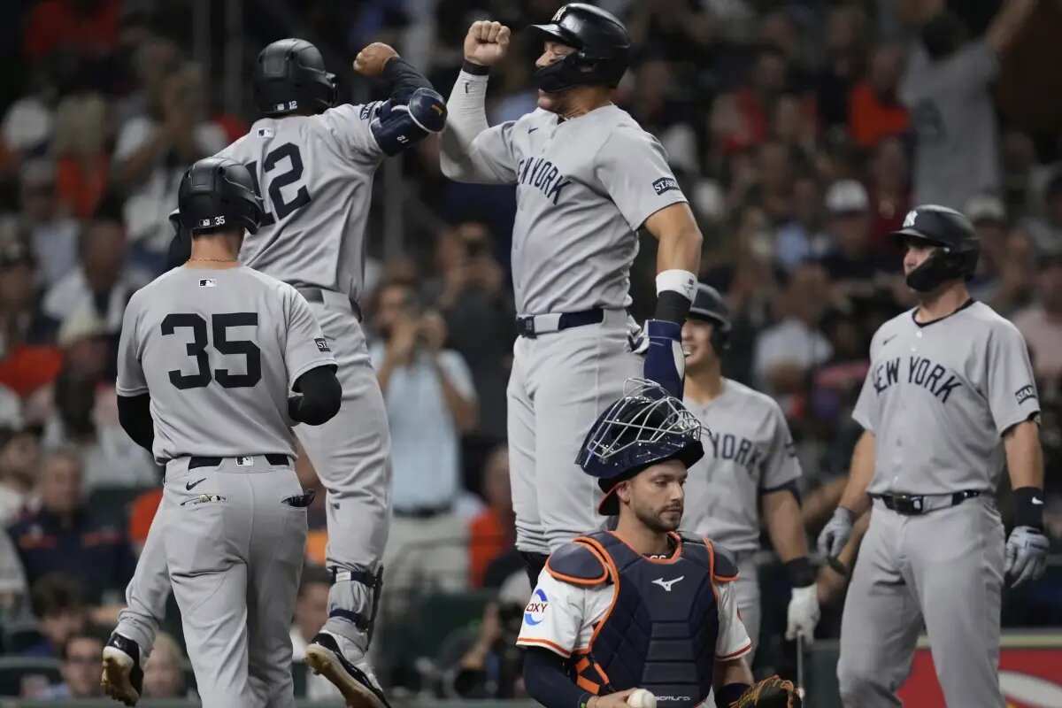 New York Yankees’ Trent Grisham (12) celebrates with designated hitter Aaron Judge, top center, after hitting a grand slam during the fifth inning of a baseball game against the Houston Astros in Houston, Tuesday, Sept. 2, 2025. Paul Goldschmidt, Cody Bellinger, and Aaron Judge also scored.